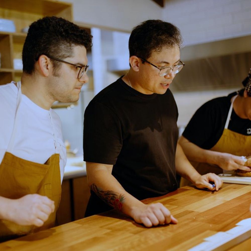 Three chefs working side by side at the kitchen pass - operational optimisation