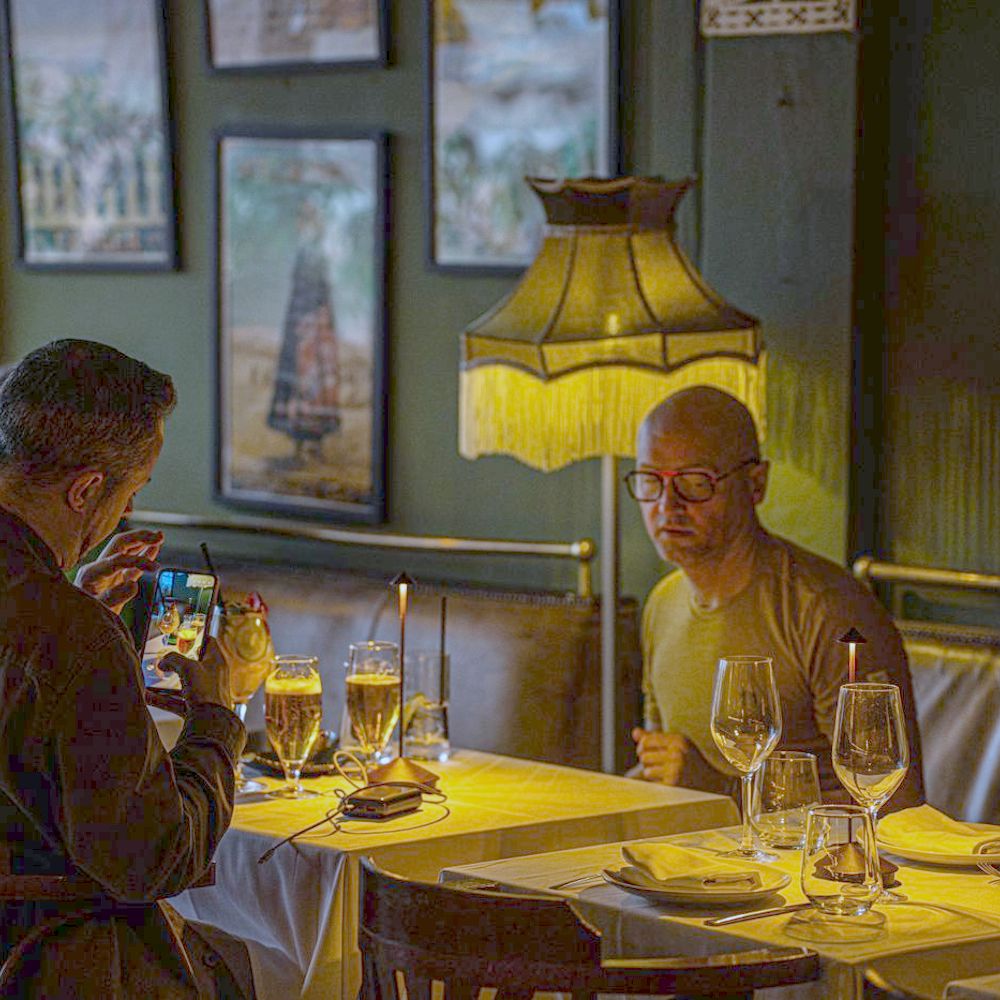 Warm dimly lit restaurant dining room with guests - strategic repositioning